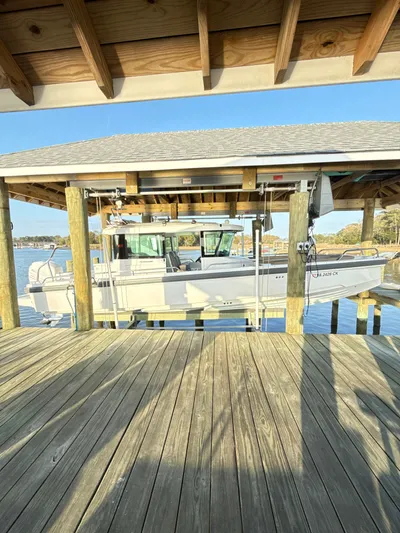  Yacht Photos Pics 2019 Axopar 28 CABIN boat docked under wooden shelter on a sunny day.