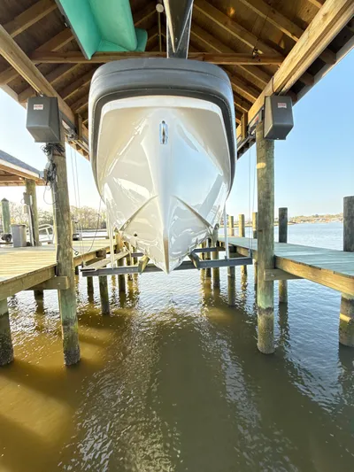  Yacht Photos Pics 2019 Axopar 28 CABIN boat docked under wooden shelter.