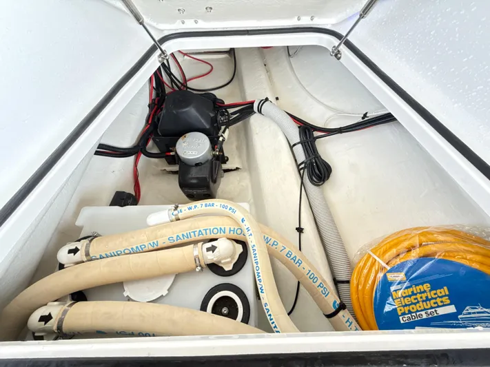  Yacht Photos Pics 2019 Axopar 28 CABIN boat storage compartment with hoses and electrical cables.