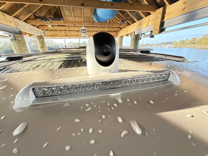  Yacht Photos Pics 2019 Axopar 28 CABIN with camera and light bar under a wooden dock.