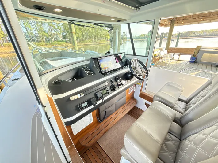  Yacht Photos Pics 2019 Axopar 28 CABIN interior with steering wheel and navigation system.