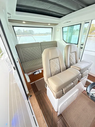  Yacht Photos Pics 2019 Axopar 28 CABIN interior with beige seating and wood flooring.
