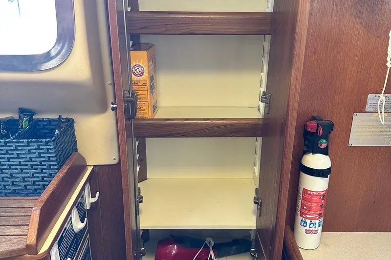 Ms Bea Haven Yacht Photos Pics Empty wooden cabinet with fire extinguisher on a 2006 Hunter 41 Deck Salon yacht.