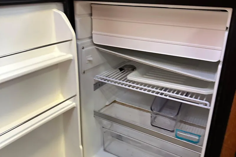 Ms Bea Haven Yacht Photos Pics Open refrigerator inside 2006 Hunter 41 Deck Salon yacht, showing shelves and storage compartments.