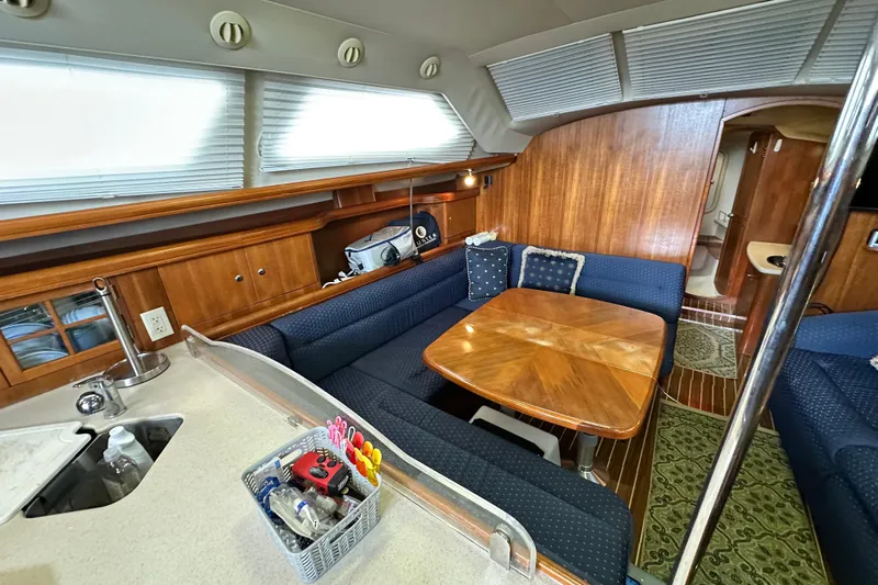 Ms Bea Haven Yacht Photos Pics Interior of 2006 Hunter 41 Deck Salon with wooden table and blue seating.