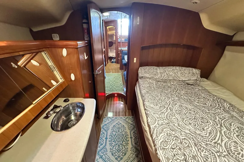 Ms Bea Haven Yacht Photos Pics Interior of 2006 Hunter 41 Deck Salon with bed, sink, and wooden cabinetry.