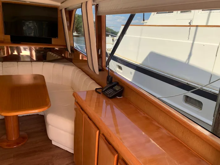 Pier Pressure Yacht Photos Pics Interior of 2000 Viking 50 Convertible yacht with wood cabinetry and white seating.