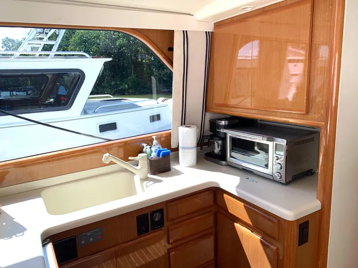 Pier Pressure Yacht Photos Pics 2000 Viking 50 Convertible yacht kitchen with sink, microwave, and wooden cabinetry.