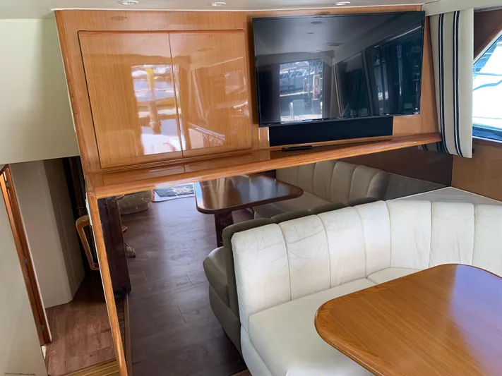 Pier Pressure Yacht Photos Pics Interior of 2000 Viking 50 Convertible yacht with white seating and wooden table.