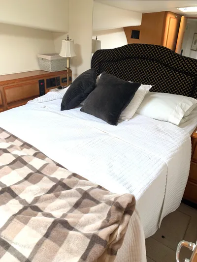 Pier Pressure Yacht Photos Pics Cozy bedroom in 2000 Viking 50 Convertible yacht with plush bedding and elegant decor.