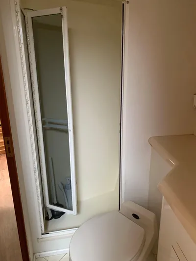 Pier Pressure Yacht Photos Pics Bathroom interior of a 2000 Viking 50 Convertible yacht, featuring a compact shower and toilet.