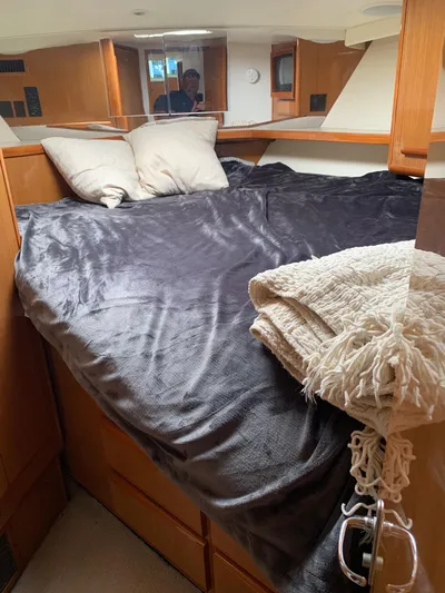 Pier Pressure Yacht Photos Pics Cozy bedroom in 2000 Viking 50 Convertible yacht with plush bedding and wooden cabinetry.