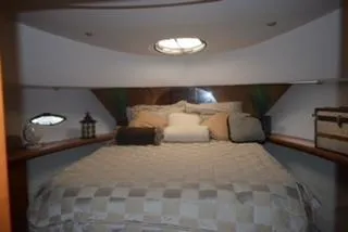  Yacht Photos Pics 2001 Silverton 410 Sport Bridge cabin with cozy bed and decorative accents.