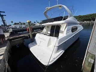  Yacht Photos Pics 2001 Silverton 410 Sport Bridge yacht docked at a marina under clear blue skies.