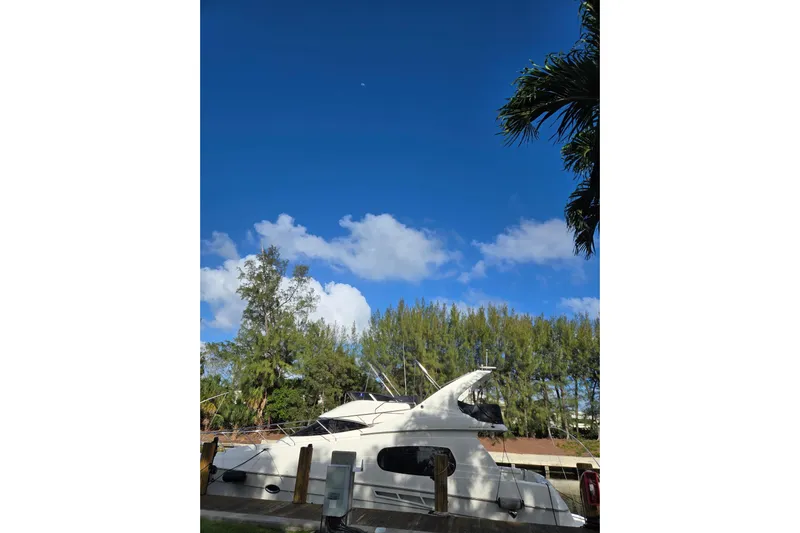  Yacht Photos Pics 2001 Silverton 410 Sport Bridge yacht docked under clear blue sky.