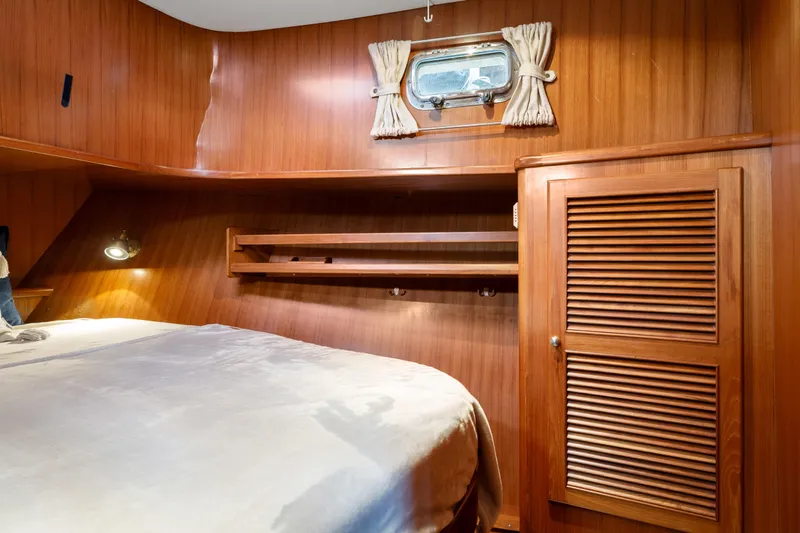Greymalkin II Yacht Photos Pics Cozy cabin interior of 2008 North Pacific 39 Pilothouse with wood paneling and porthole window.