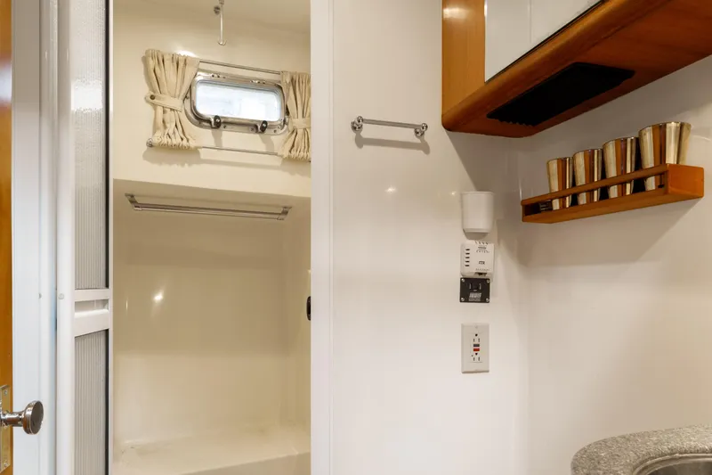 Greymalkin II Yacht Photos Pics Bathroom interior of 2008 North Pacific 39 Pilothouse yacht with shower and wooden shelves.