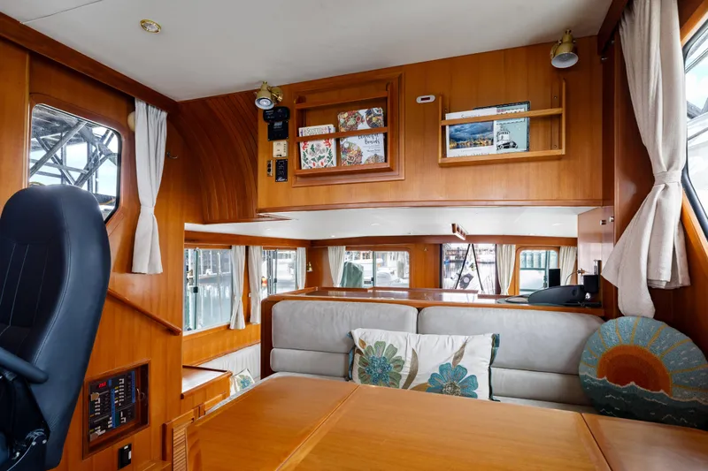 Greymalkin II Yacht Photos Pics Interior of 2008 North Pacific 39 Pilothouse with wood paneling and cozy seating area.