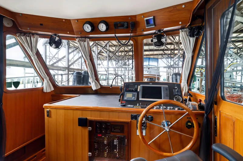 Greymalkin II Yacht Photos Pics Pilothouse interior of 2008 North Pacific 39, featuring wooden helm and navigation equipment.