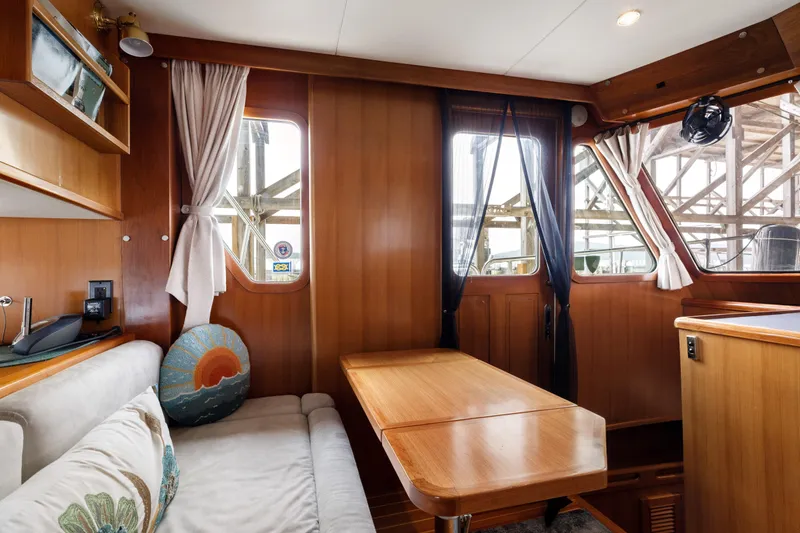 Greymalkin II Yacht Photos Pics Interior of 2008 North Pacific 39 Pilothouse with wooden paneling and cozy seating area.