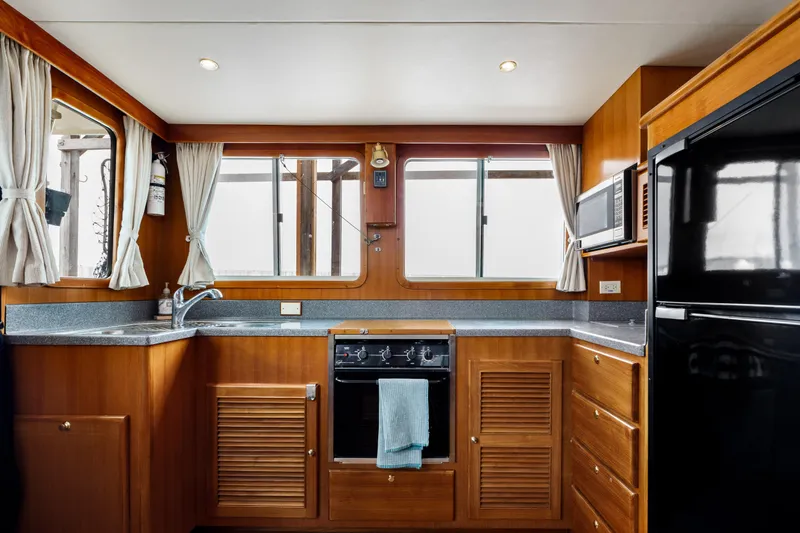 Greymalkin II Yacht Photos Pics Interior of 2008 North Pacific 39 Pilothouse yacht kitchen with wood cabinetry and appliances.