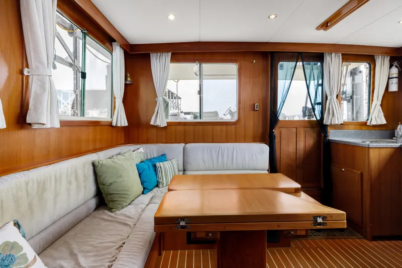 Greymalkin II Yacht Photos Pics Interior of 2008 North Pacific 39 Pilothouse with cozy seating and wooden table.