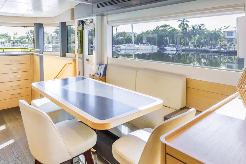 Fantasea Yacht Photos Pics Luxurious interior of 2020 Sirena 64 yacht with elegant dining area and scenic window view.