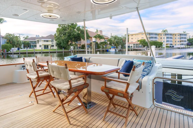 Fantasea Yacht Photos Pics Luxurious 2020 Sirena 64 yacht deck with elegant seating and scenic waterfront view.
