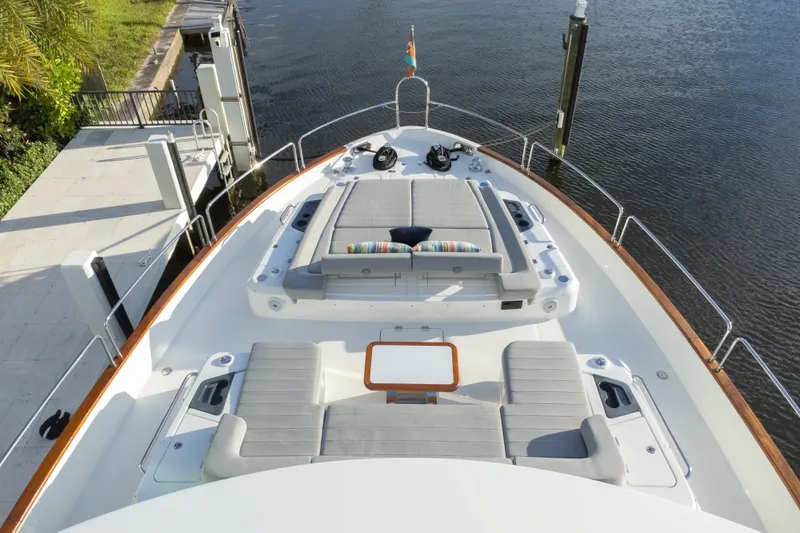 Fantasea Yacht Photos Pics Luxurious 2020 Sirena 64 yacht deck with sun loungers and table, docked by calm waters.