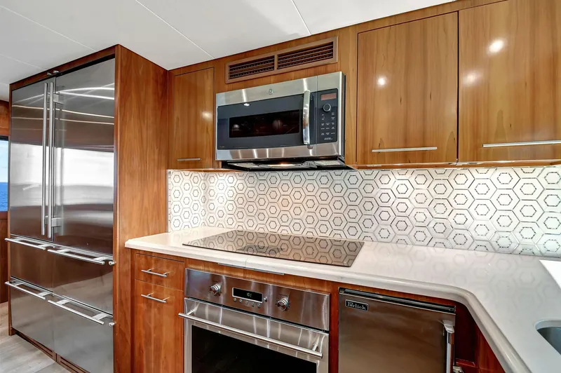 Danielle Yacht Photos Pics Luxurious 2005 Hatteras Semi-Displacement yacht kitchen with modern appliances and hexagonal tile backsplash.