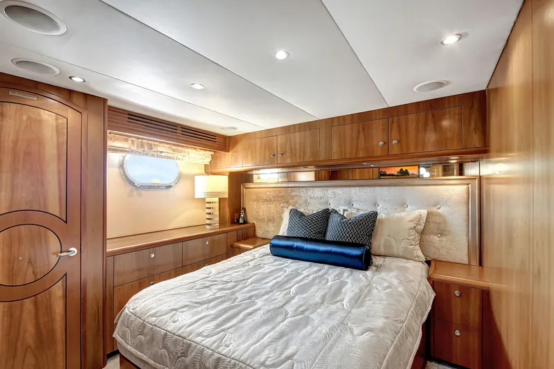 Danielle Yacht Photos Pics Luxurious 2005 Hatteras Semi-Displacement yacht bedroom with elegant wood paneling and cozy bedding.