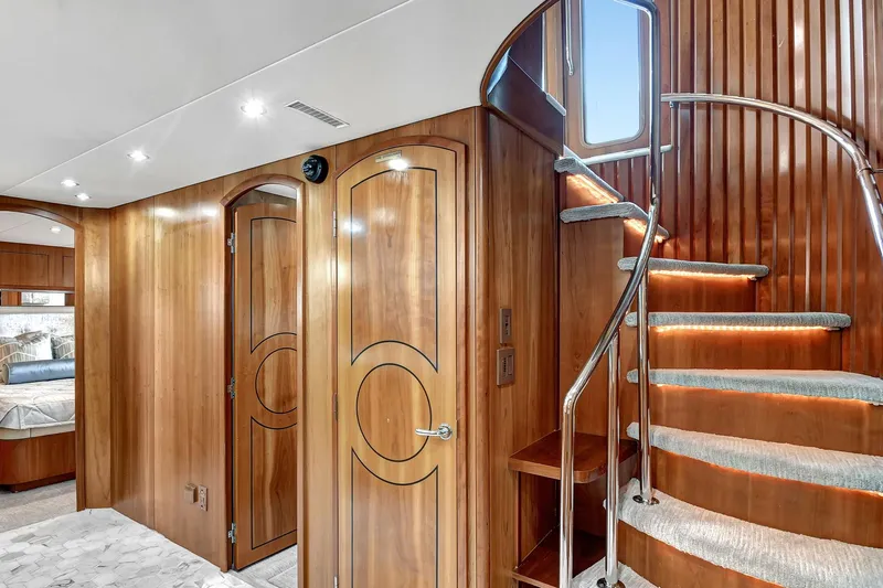 Danielle Yacht Photos Pics Luxurious 2005 Hatteras Semi-Displacement yacht interior with elegant wood paneling and spiral staircase.