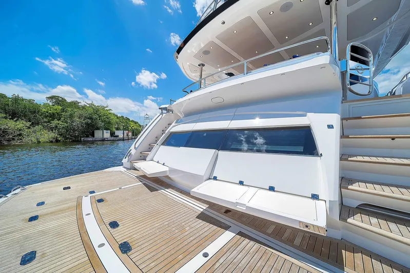  Yacht Photos Pics Luxury Sunseeker 86 yacht, 2019 model, docked by a serene river under a clear blue sky.