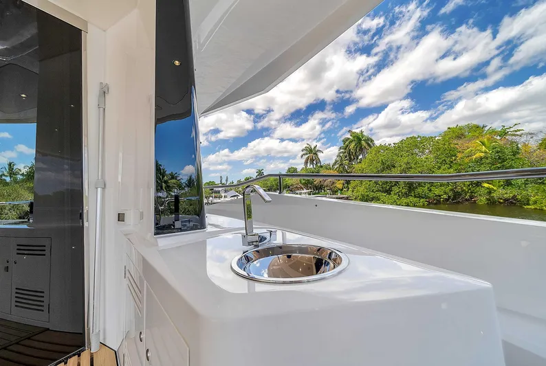  Yacht Photos Pics Luxurious Sunseeker 86 yacht deck with sink, 2019 model, under a vibrant blue sky.