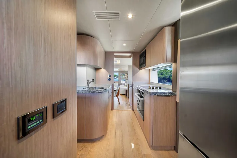  Yacht Photos Pics Modern kitchen interior of 2019 Sunseeker 86 yacht with sleek wood cabinetry and stainless steel appliances.