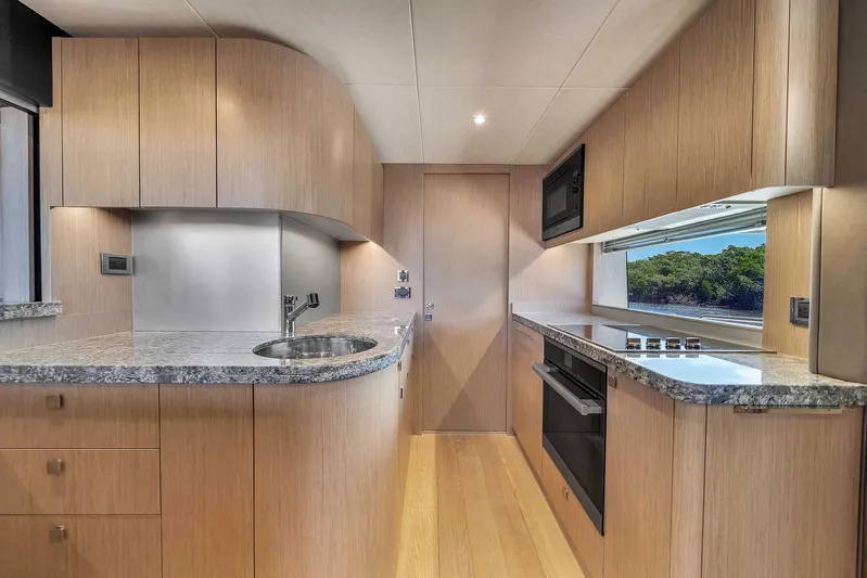  Yacht Photos Pics Modern kitchen interior of 2019 Sunseeker 86 yacht with sleek wood cabinetry and granite countertops.