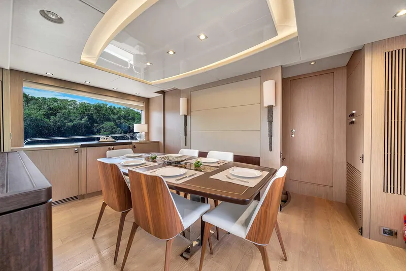  Yacht Photos Pics Luxurious dining area on 2019 Sunseeker 86 yacht with elegant wood finishes.
