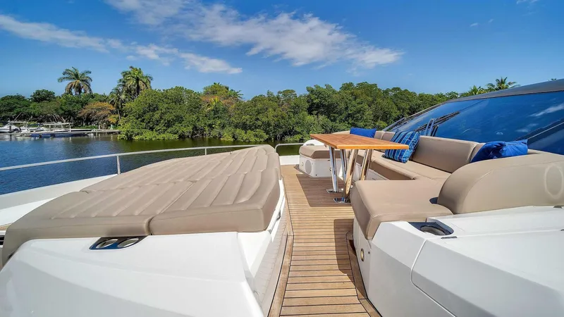  Yacht Photos Pics Luxurious 2019 Sunseeker 86 yacht deck with seating and table, surrounded by lush greenery.