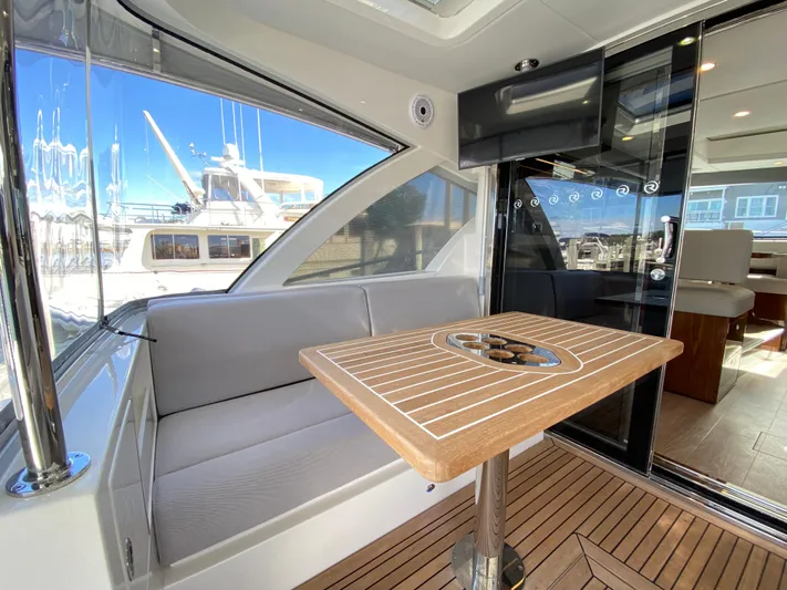  Yacht Photos Pics Luxurious interior of 2025 Riviera 465 SUV yacht with elegant seating and wooden table.