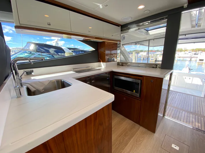  Yacht Photos Pics Luxurious 2025 Riviera 465 SUV yacht kitchen with modern appliances and sleek design.