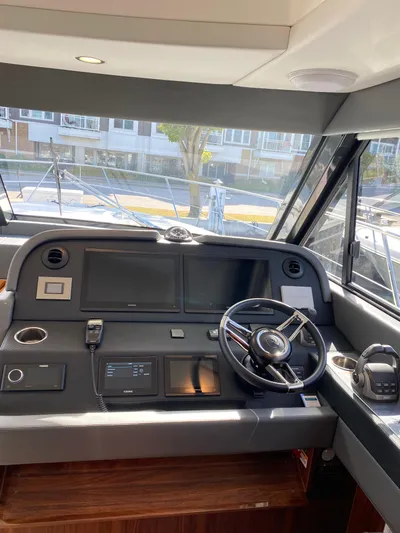  Yacht Photos Pics Interior helm of 2025 Riviera 465 SUV yacht with modern controls and steering wheel.