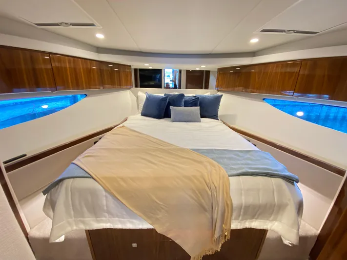  Yacht Photos Pics Luxurious bedroom interior of 2025 Riviera 465 SUV yacht with elegant bedding and wood accents.