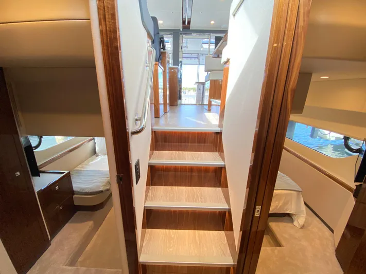  Yacht Photos Pics Interior of 2025 Riviera 465 SUV yacht, featuring luxurious cabins and wooden staircase.