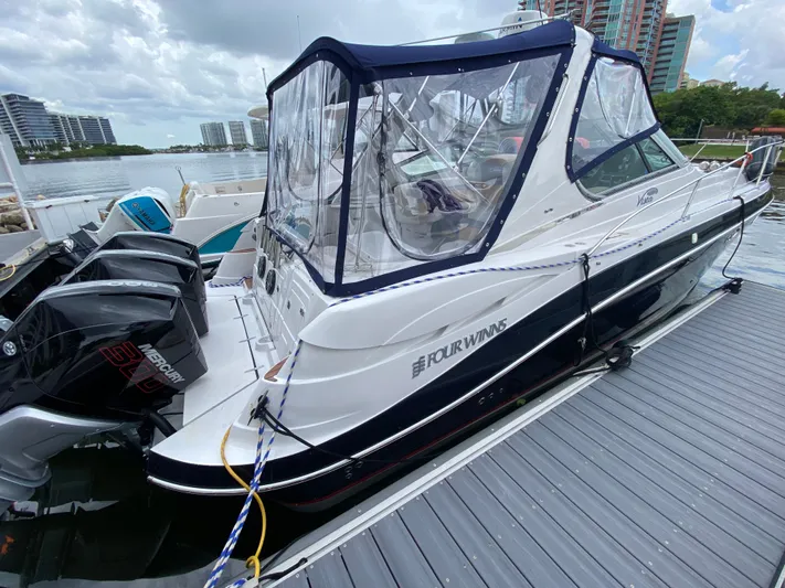  Yacht Photos Pics 2006 Four Winns 348 Vista boat docked with Mercury engines, clear canopy, and cityscape background.