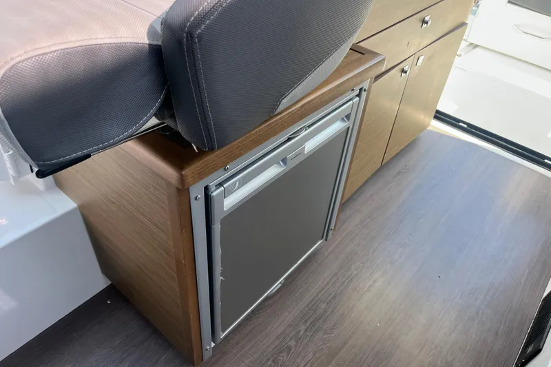  Yacht Photos Pics Interior of 2020 Jeanneau NC 895 boat with compact fridge and seating.