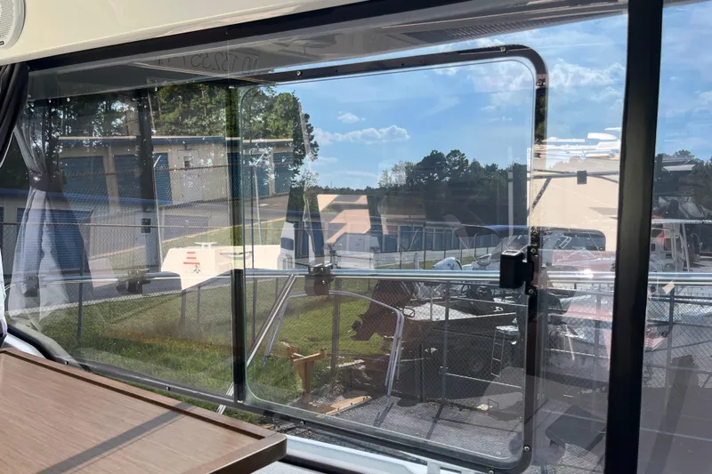  Yacht Photos Pics View from Jeanneau NC 895 boat window, showcasing outdoor scenery and clear skies.