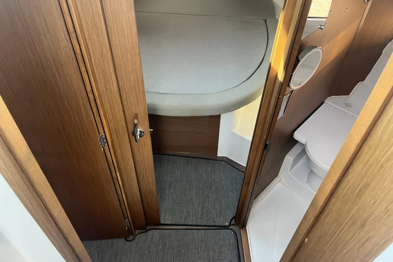  Yacht Photos Pics 2020 Jeanneau NC 895 interior cabin with bed and compact bathroom.