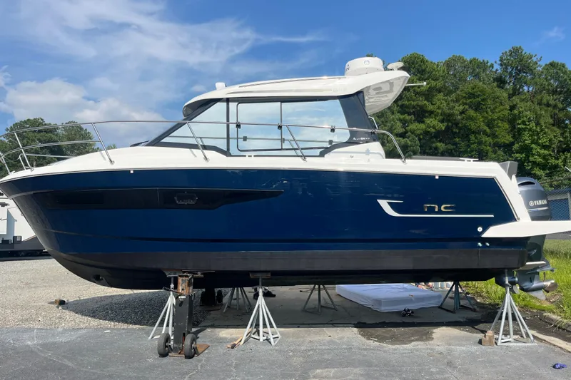  Yacht Photos Pics 2020 Jeanneau NC 895 boat on stands, blue hull, outdoors, sunny day.