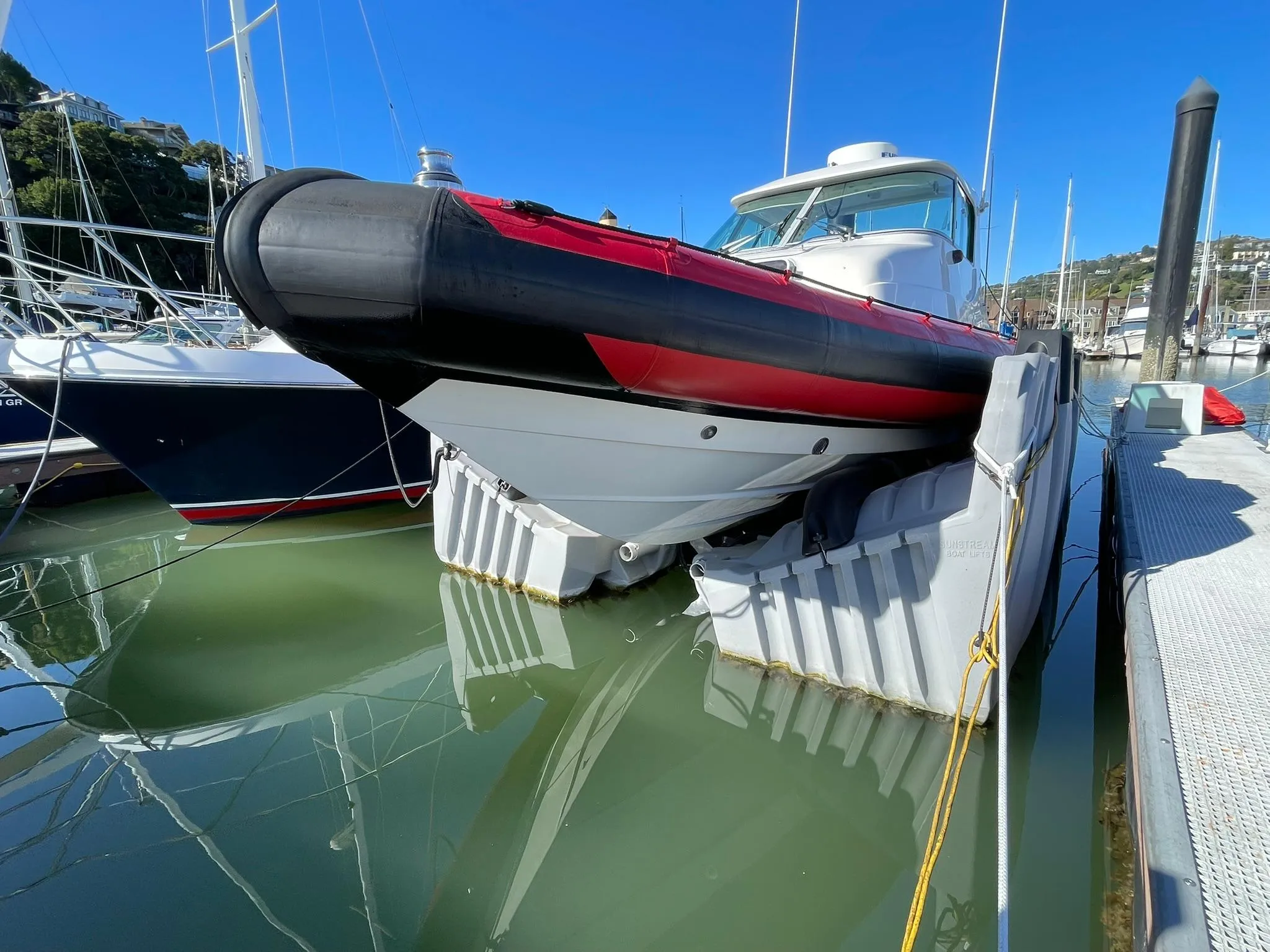 2001 Protector Targa 28 boat docked in marina, featuring red and black detailing.