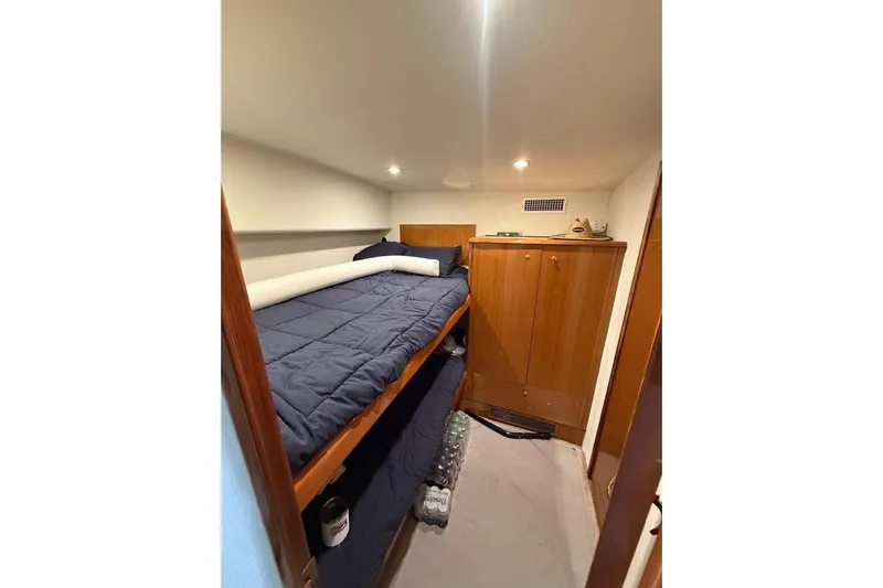  Yacht Photos Pics 2003 Viking Convertible cabin with bunk beds and wooden storage cabinets.